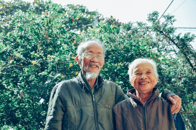 一对年长的夫妇在户外一起微笑。